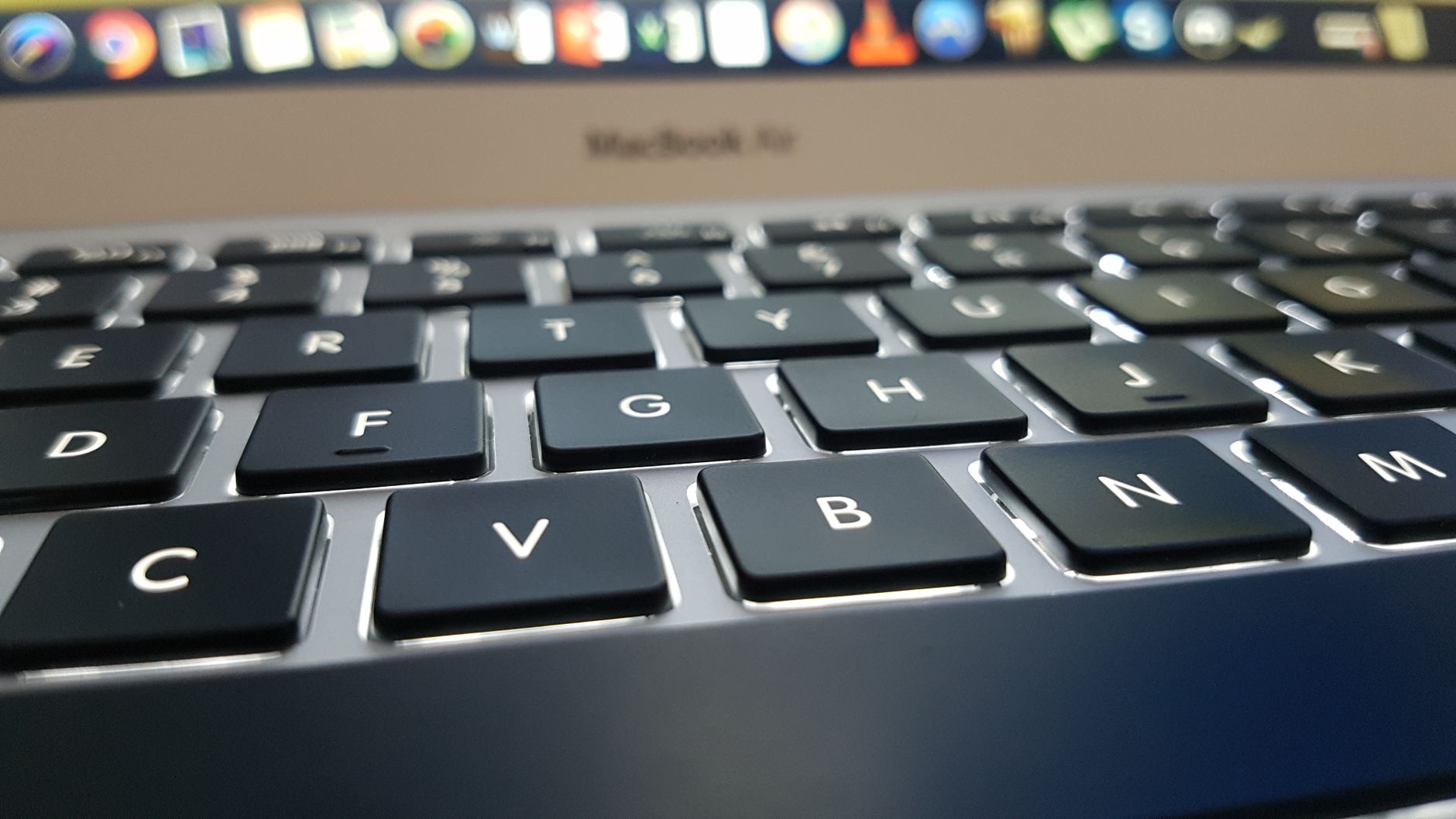 Vista detallada del teclado de un MacBook Air, con el foco en las teclas y la iluminación suave.